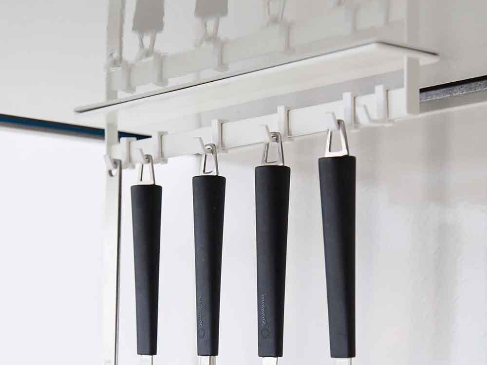 銀色の棚にマグネットレンジフードフックが掛かっている