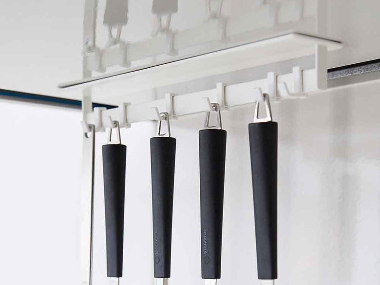 銀色の棚にマグネットレンジフードフックが掛かっている