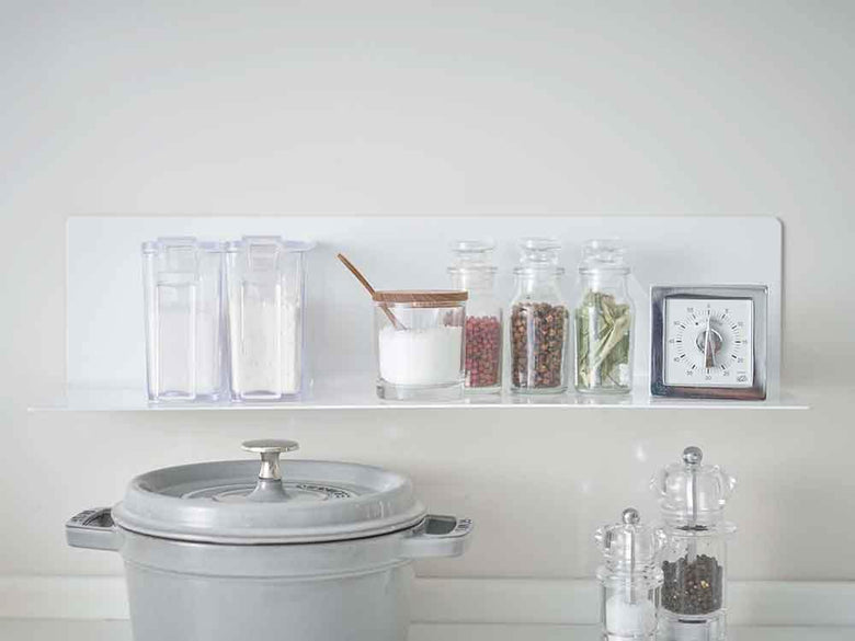 磁石付きキッチン棚に食器やグラスが配置されている