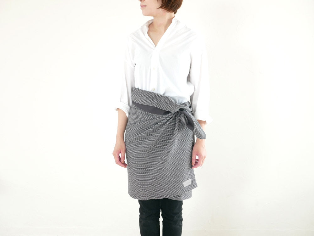 ポケットとウエストに柄が施されたオーガニックコットン100％のピケ織り155×60cmタオルがラップされた状態