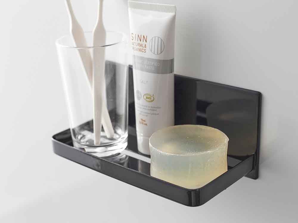 YAMAZAKI/tower製マグネットバスルームラックが浴室の壁に設置され、ボトルやキッチン用品を整理している様子