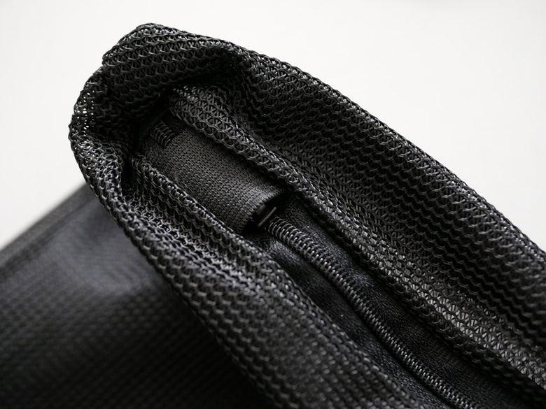 グレーのメッシュ素材にレザーのストラップとシルバーのジッパーが付いたサラサデザインのランドリーネットバッグ