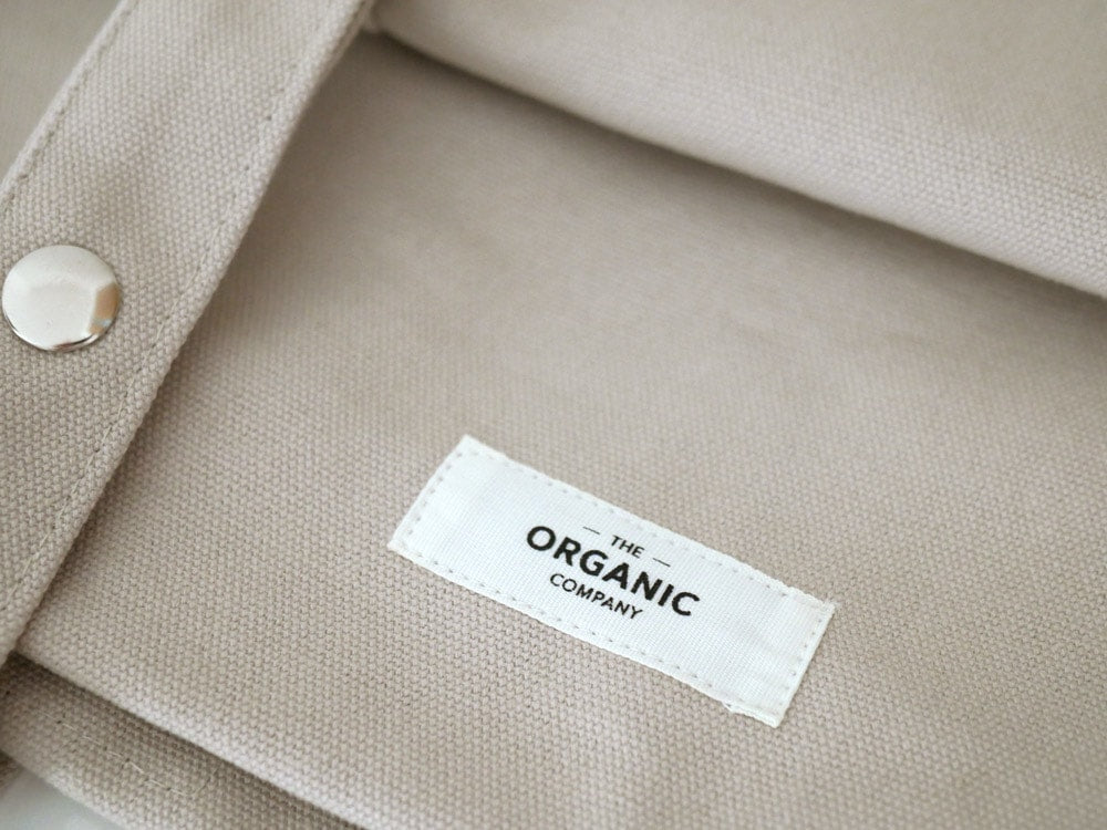 THE ORGANIC COMPANYのSMALL BAG。オーガニックコットン100％のヘビーキャンバス素材を使用し、ボタンとポケットが特徴的な小型バッグ。インド製。