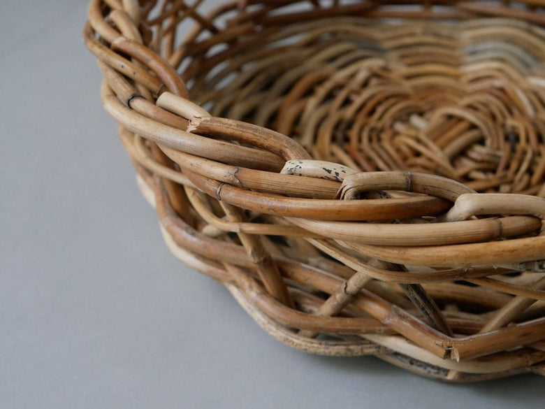 オーバル型天然ウィッカーバスケットに食器が収納されています