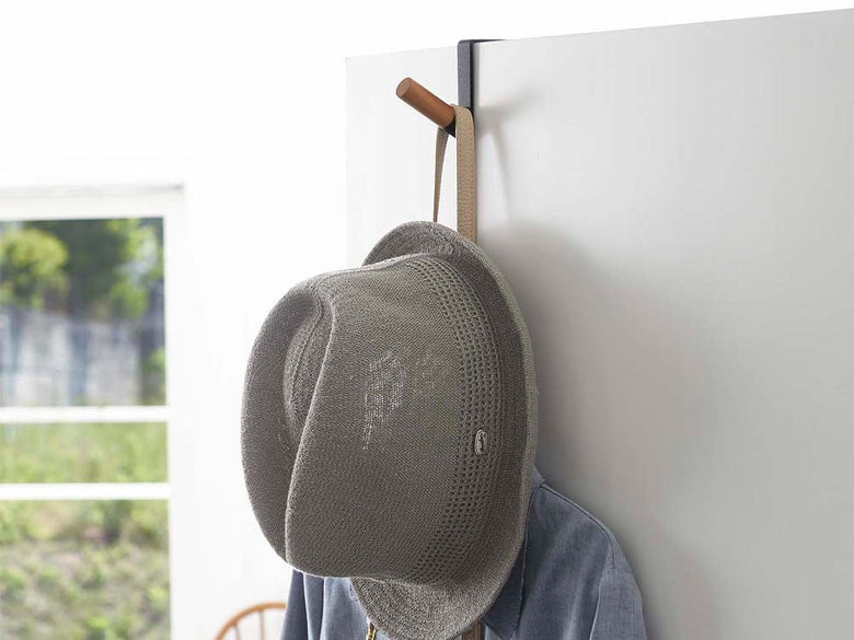 タワーのドアハンガーに帽子やバッグが掛かっている