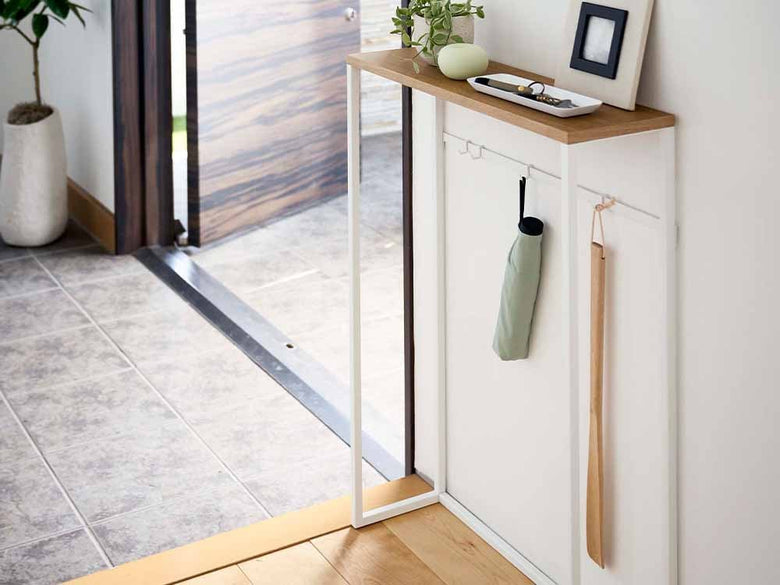 木製コンソールテーブルと観葉植物が配置されたフローリング