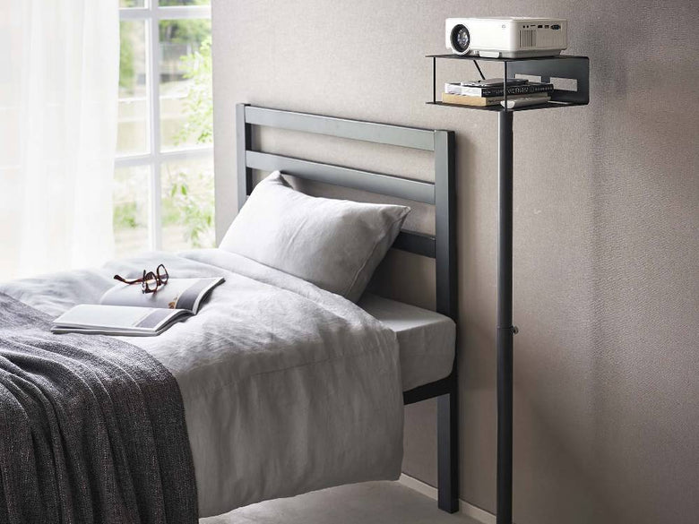 ベッド、ナイトスタンド、ランプが配置された寝室