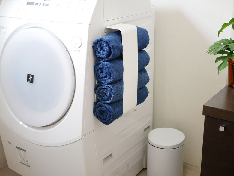 YAMAZAKI製スチールマグネットバスタオルホルダーが洗濯機と乾燥機の近くに設置され、約4枚のバスタオルを掛けている様子