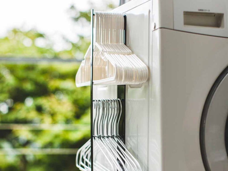 YAMAZAKI/towerブランドの銀色2段マグネット洗濯ハンガー収納ラックがスチール製の壁面に取り付けられている様子