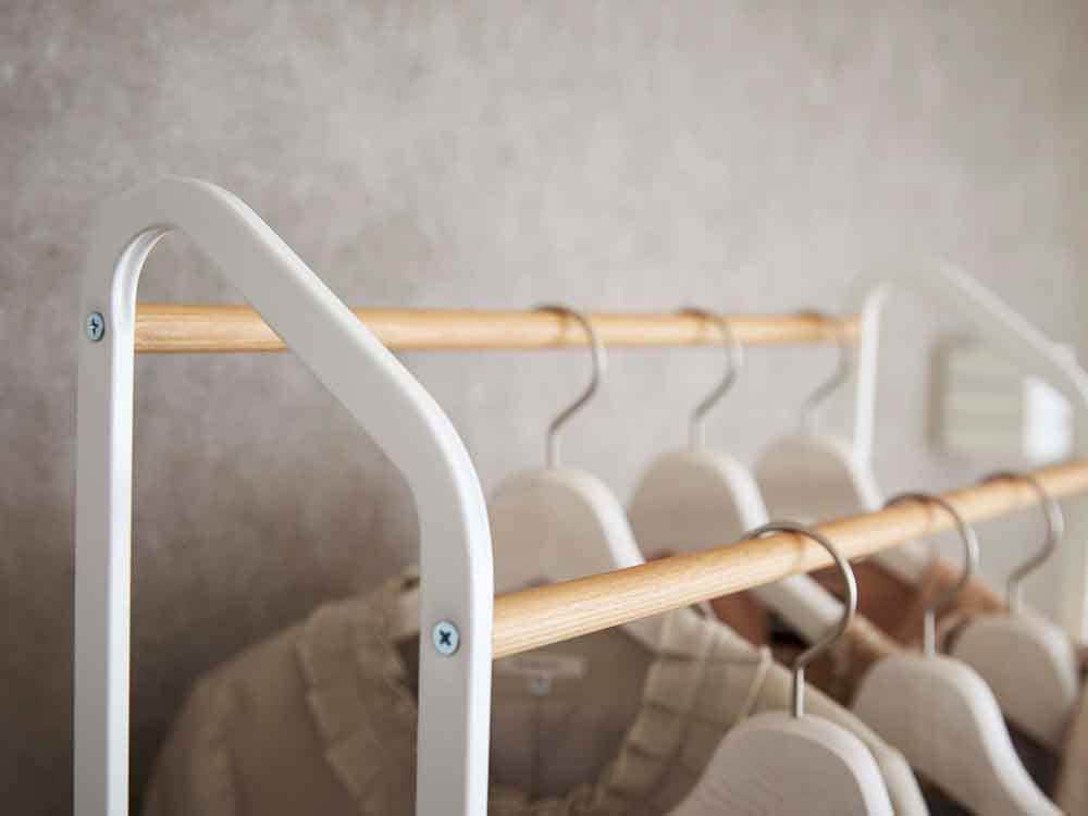 YAMAZAKI Towerのキャスター付きハンガーラック、天然木のバーとスチール本体を組み合わせたデザイン