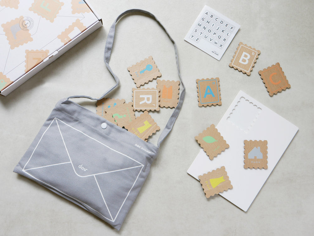 douブランドのABCスタンプセットに含まれる木製ABCカード、アクリルボード、ショルダーバッグが並んだ製品写真