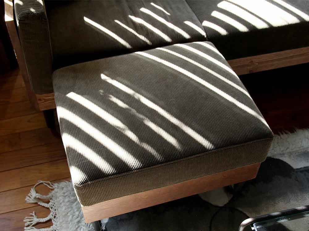 ブラウン木製オットマンとクッションがあるリビングルーム