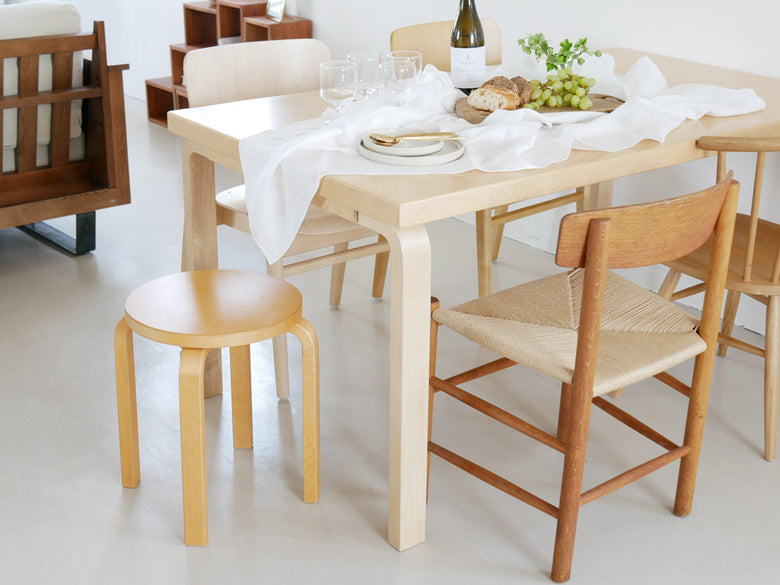 アルテック製バーチ材スツール60/E60が木製ダイニングテーブル周辺に配置されたダイニングルームのインテリア