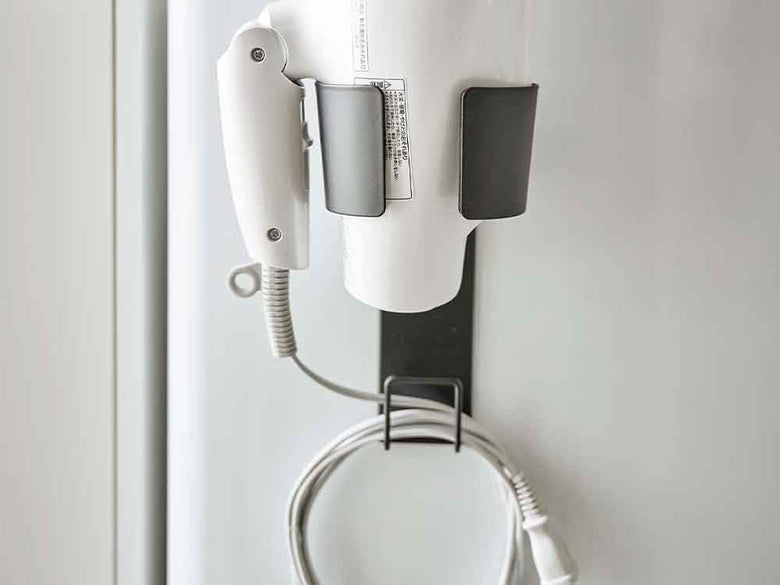 銀色のマグネットドライヤーホルダーが壁に取り付けられている