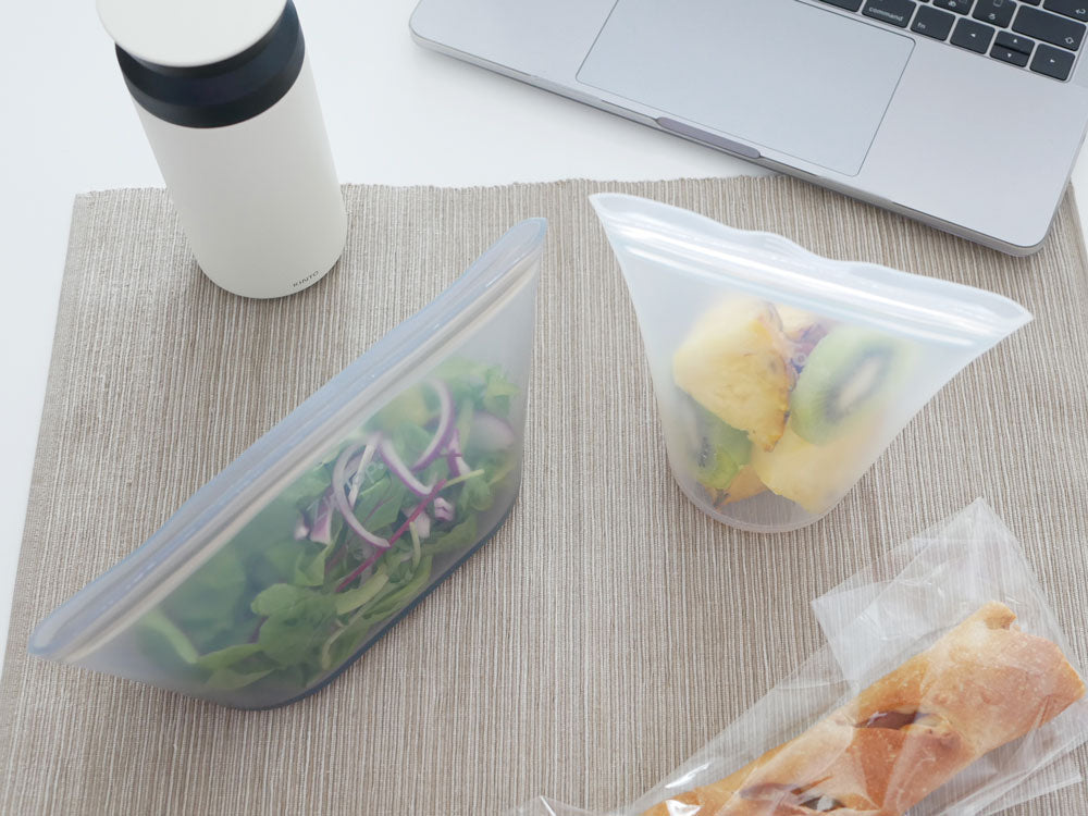 Zip Topブランドのプラチナシリコーン製ディッシュにフルーツが盛られ、キッチン用具と共にトレー上に配置されている様子