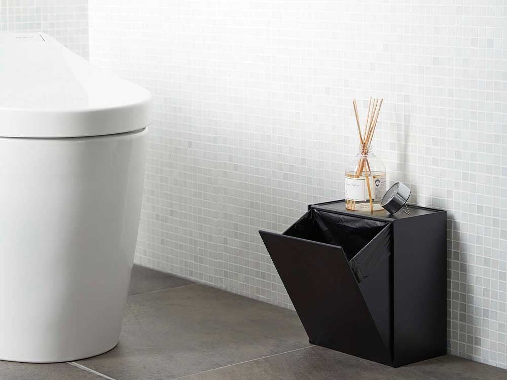 シルバー色のタワーウォールトイレポットと収納ケースが設置された浴室