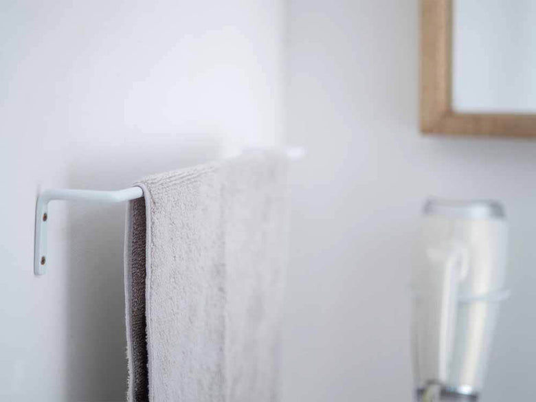 白いアイアン製ドライヤーホルダーが壁に設置されている