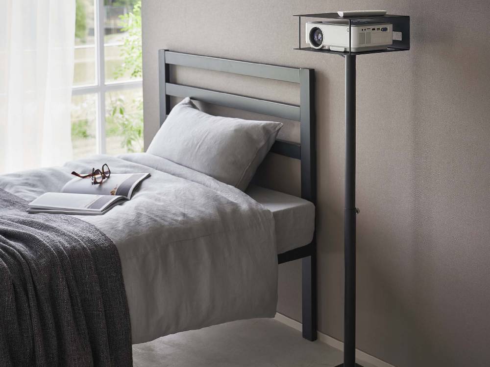 高さ伸縮プロジェクタースタンドとベッドが配置された寝室