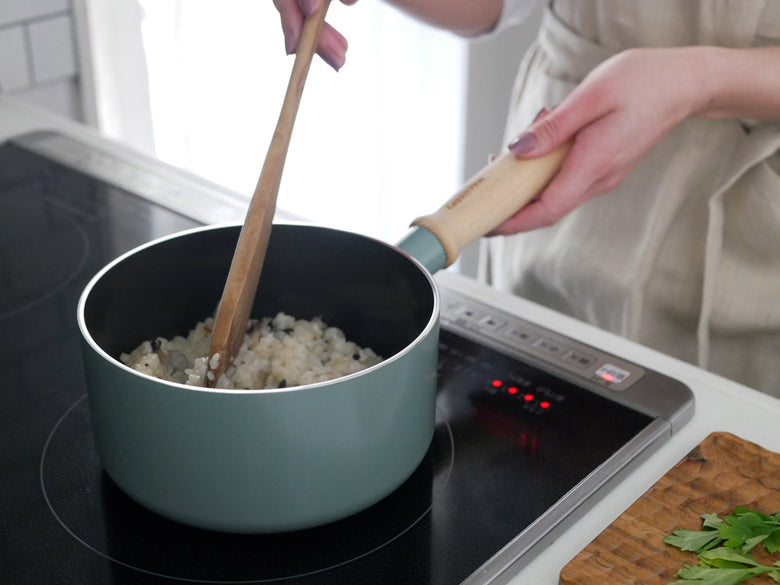 GREENPANのメイフラワー ソースパン蓋付き、セラミックコーティングのアルミ製鍋と透明ガラス蓋がキッチンのコンロ上に置かれている様子