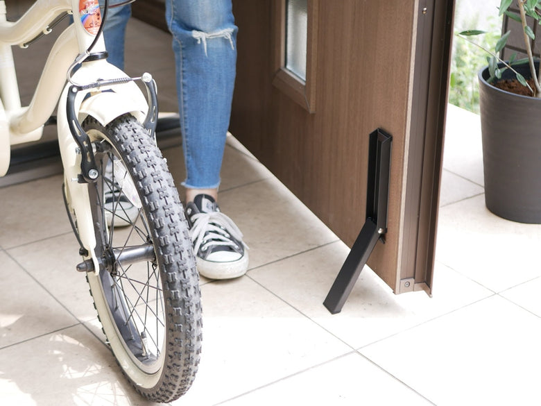 磁石で固定できるtowerブランドの折り畳み式スマートマグネットドアストッパー。スチールとシリコン素材でコンパクトに収納可能