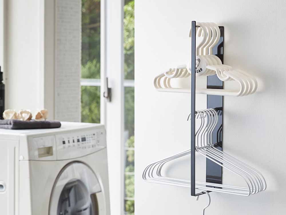 YAMAZAKI/towerのマグネット洗濯ハンガー収納ラック。スチール製の2段棚に衣類ハンガーや洗濯用品が整然と配置された様子。