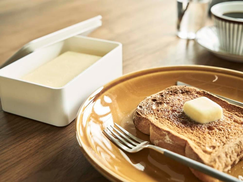 密封バターケースとパンが置かれた食卓