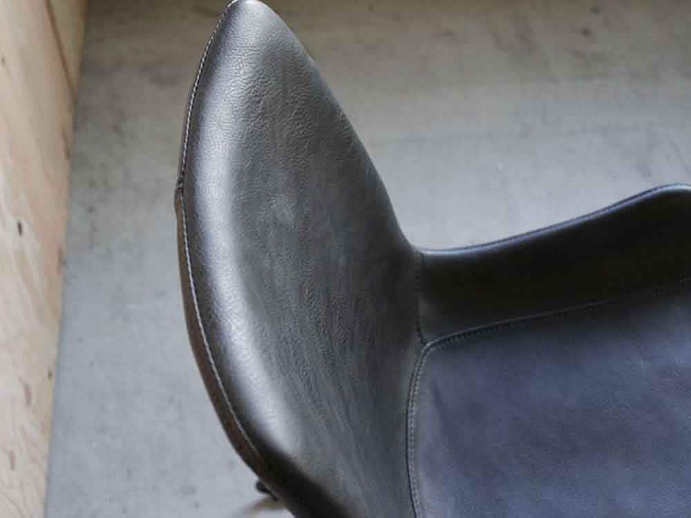 スチールとウッドのフレームを持つグレーのレザーウィングチェア