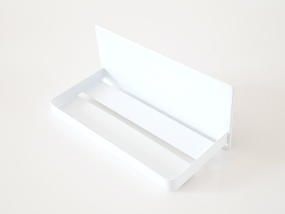 YAMAZAKI/towerのスチール製マグネットバスルームラックが磁石で壁に固定され、タオルや小物を掛けている様子