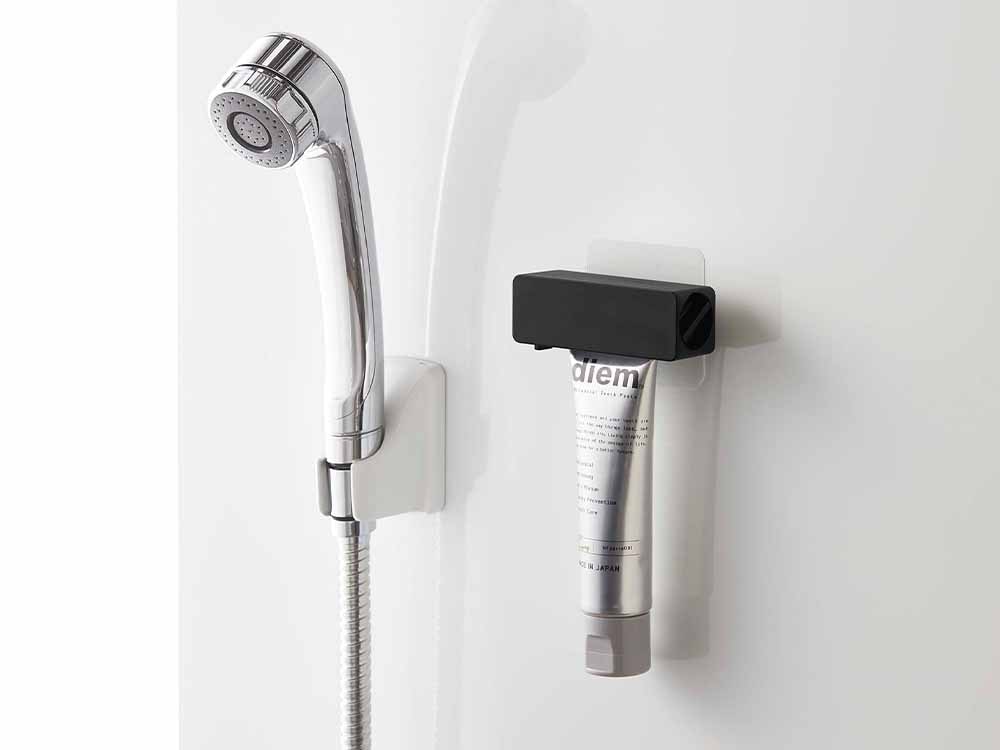 壁に設置されたタワー製歯磨き粉チューブホルダー