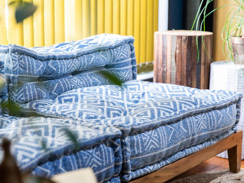 青色ソファと柄入りクッションが配置されたリビングルーム