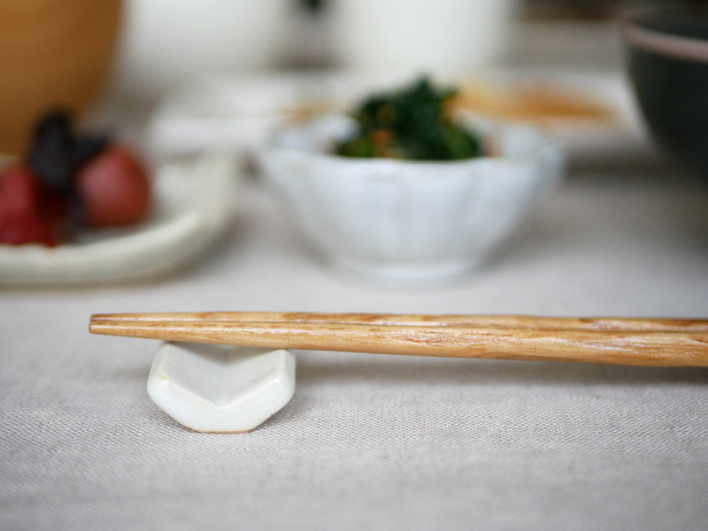 sarasa design×イブキクラフトの白色陶器製箸置きと他の食器が並んだテーブル上の写真
