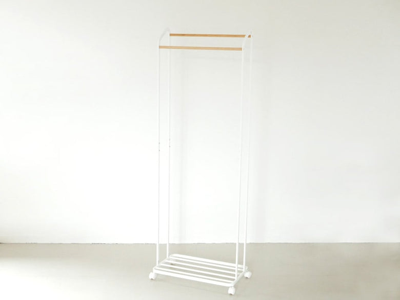 YAMAZAKI/towerのキャスター付きハンガーラックに衣類が掛けられている家庭用収納用品の画像