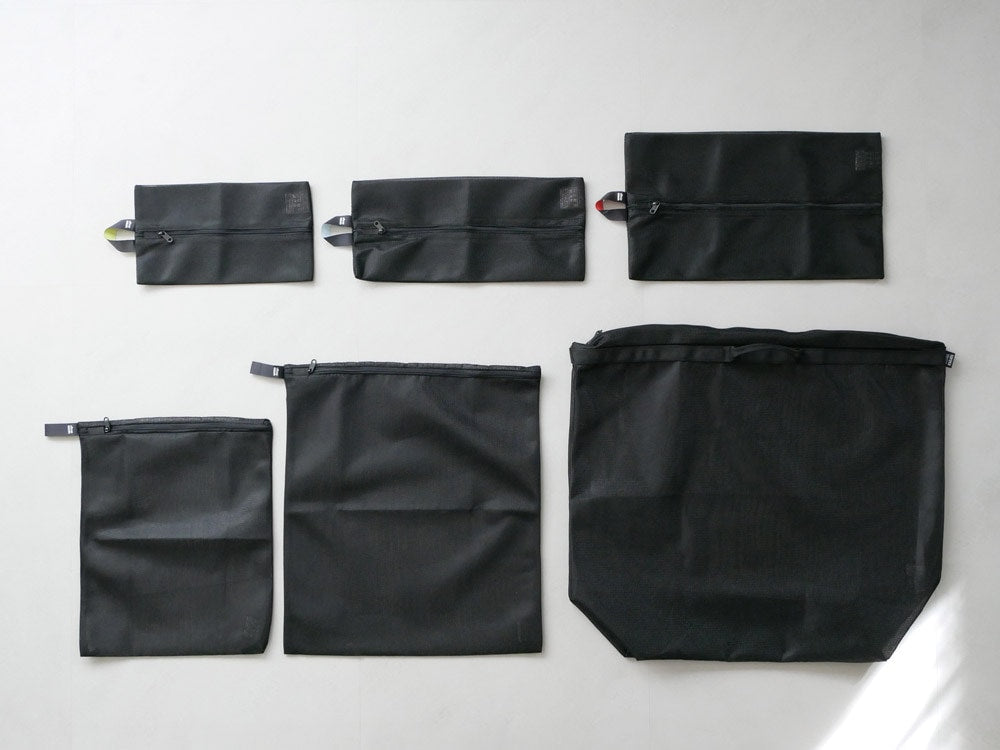 sarasa designの黒いワイドランドリーネット。肩掛けストラップとポケットが付いたポリエステル製の洗濯用バッグ