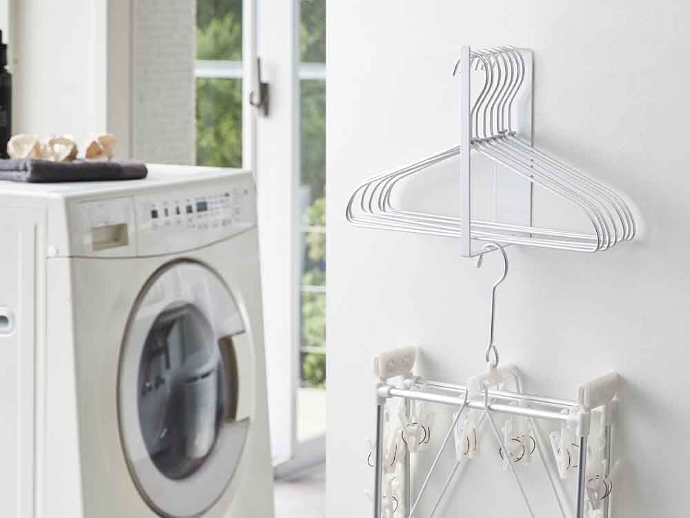 洗濯室の壁に取り付けられた銀色のマグネット式2段洗濯ハンガー収納ラック。スチール製で洗濯機や乾燥機の近くに配置されています。