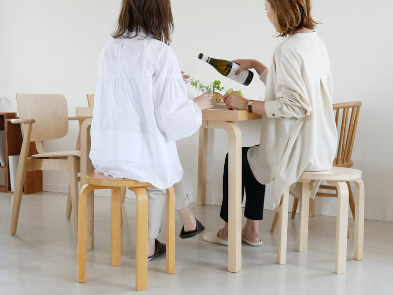 デザイナーアルヴァ・アルトのバーチ材スツール60/E60。アームレスト付きの快適な木製椅子。