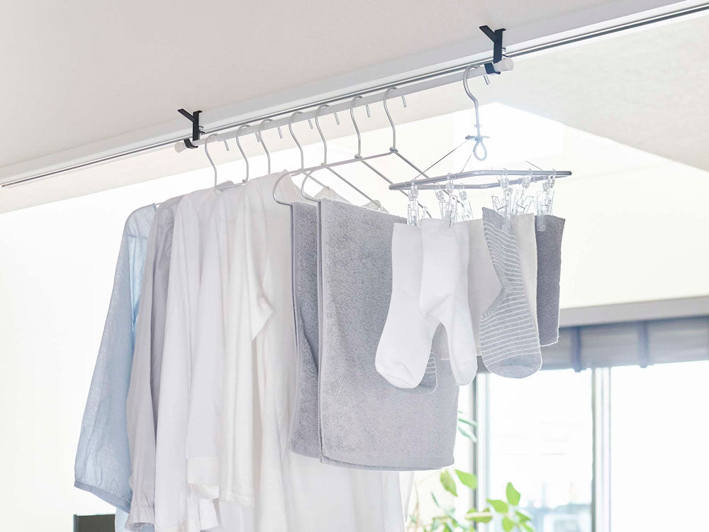 室内物干しフックが天井に取り付けられ衣類を掛けている