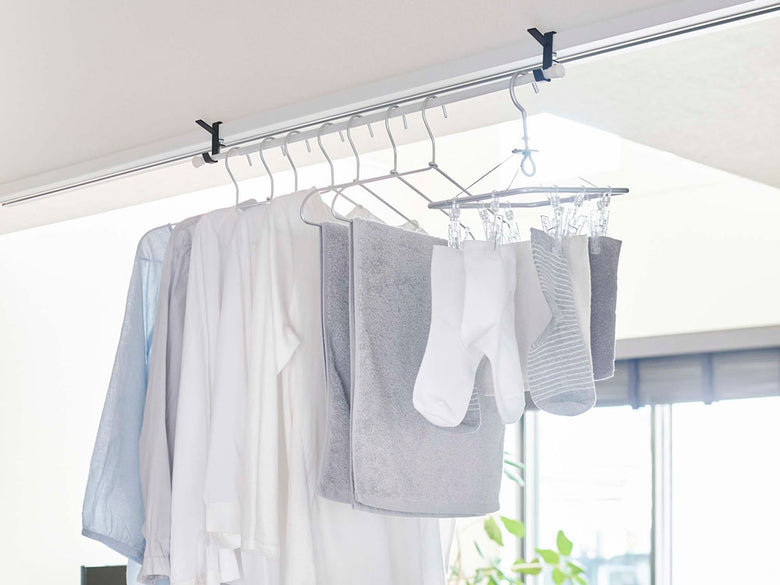 室内物干しフックが天井に取り付けられ衣類を掛けている