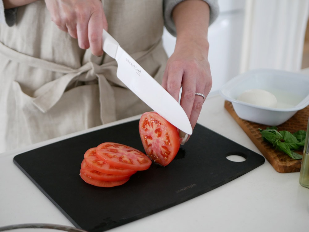 京セラココチカルシリーズのペティナイフ、三徳包丁、シェフズナイフと新鮮な野菜や果物が並ぶキッチン用品の画像