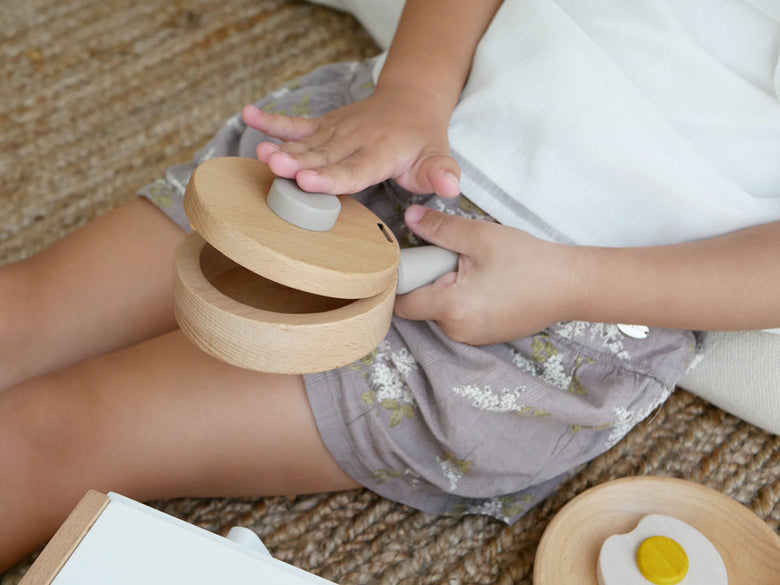 douのままごとがっき pop panセットに含まれるフライパン、たまご、ハンバーグ、フライ返しなどの調理おもちゃ