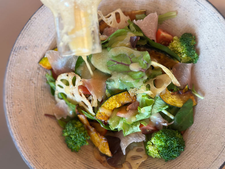 OXOブランドの小型クリアサラダスピナー。透明なボウルと蓋が特徴で、キッチンでサラダを洗って水切りする際に使用されます。