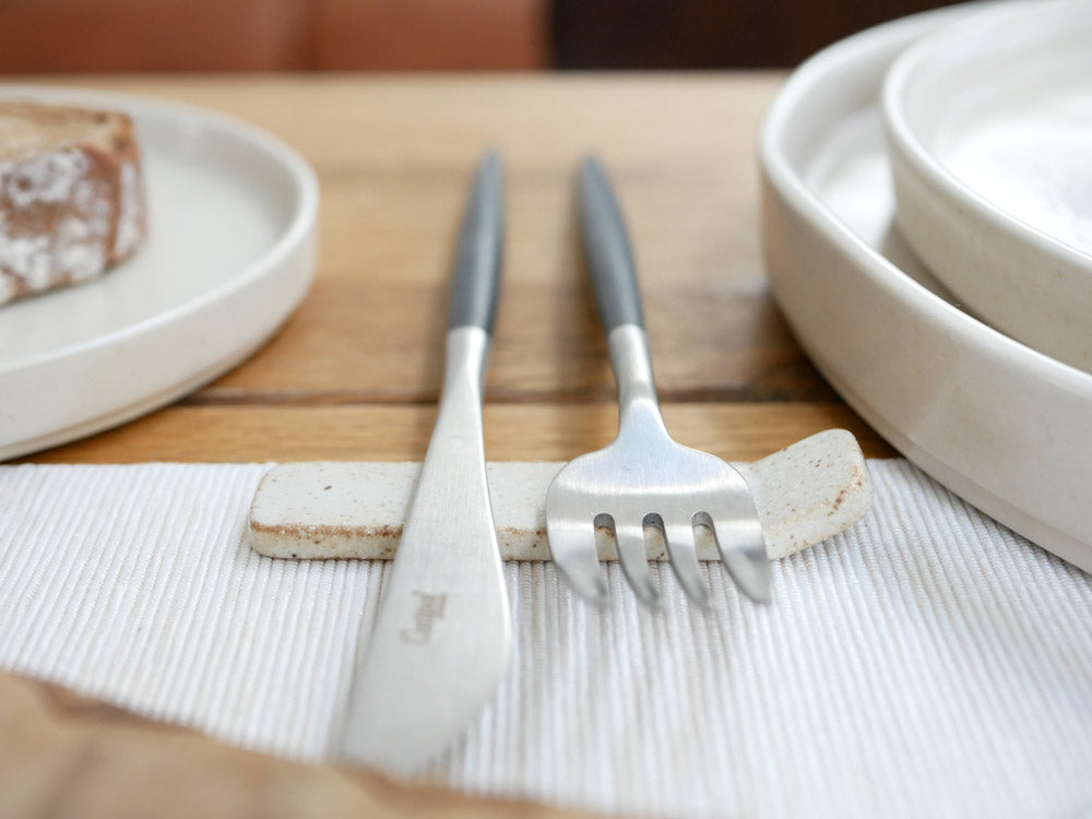 sarasa design×イブキクラフトの陶器製カトラリーレストとナイフがプレート上に配置されている