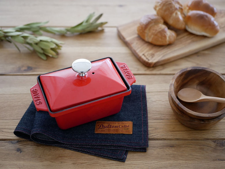 ダルトンの赤いコットンプレイスマットと調理器具が並ぶテーブル