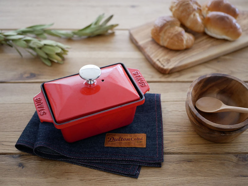 ダルトンの赤いコットンプレイスマットと調理器具が並ぶテーブル