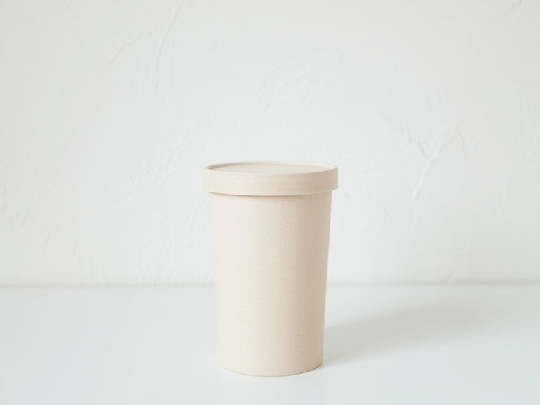 ホーンプリーズECOキャニスターのプラスチック製シリンダーと蓋、コーヒーカップスリーブが並べられたセット