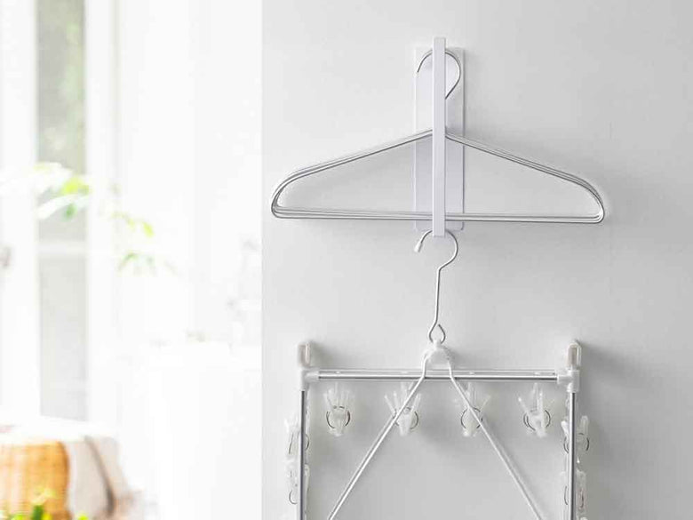 YAMAZAKI/towerブランドの2段マグネット洗濯ハンガー収納ラックが金属製の壁面に取り付けられている様子