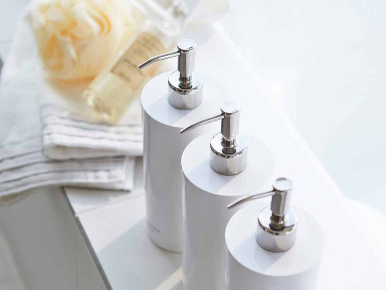 YAMAZAKI/toscaの白色ツーウェイディスペンサーが洗面台に置かれたデザイン性の高いバスルームの様子