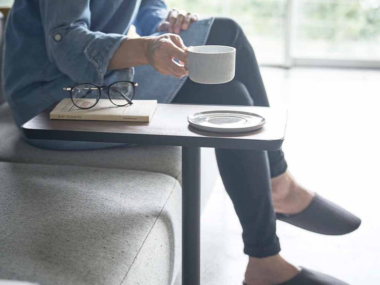 タワー差し込みサイドテーブルにカップやクッションが置かれている