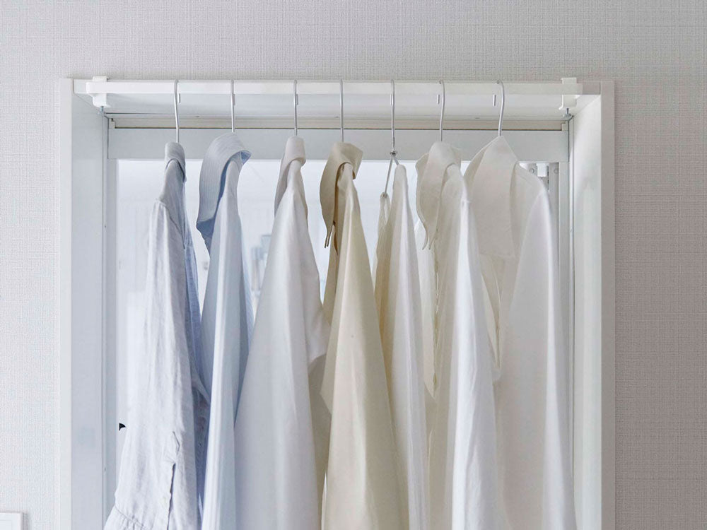 towerのグレー室内物干しハンガーがクローゼットに取り付けられている