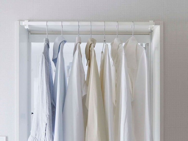 towerのグレー室内物干しハンガーがクローゼットに取り付けられている