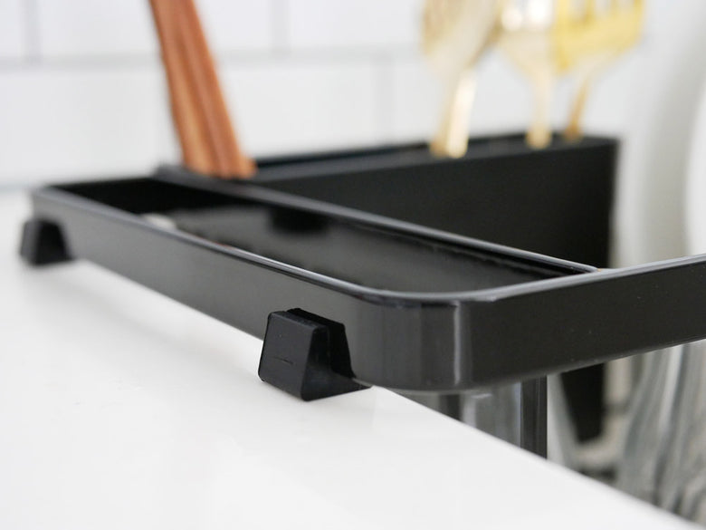 YAMAZAKIタワーの伸縮式ワイヤーバスケットがシンクに設置され、食器やカトラリーを整理している様子